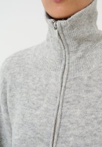 Maglione grigio con zip in morbido tessuto a maglia testurizzata, caratterizzato da un colletto alto e un dettaglio con zip argentata al collo.