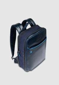 Mochila azul marino con un diseño moderno y elegante. Fabricada con tela resistente con un acabado brillante y detalles en azul. Cuenta con cremalleras y correas acolchadas.