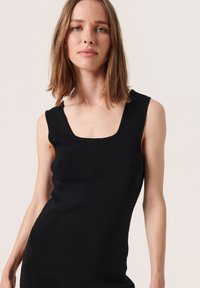 Robe noire sans manches avec un décolleté carré et une coupe ajustée, fabriquée en tissu lisse et texturé.