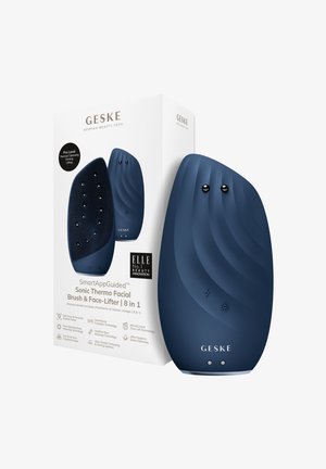 Sonic facial brush in dark blue, featuring a textured design, dual buttons, and a sleek shape, packaged in a white box with branding details.