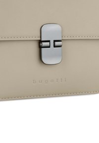 Borsa in pelle beige con chiusura metallica grigia. Presenta il nome del marchio in rilievo e cuciture ordinate lungo i bordi, che mostrano un design elegante.