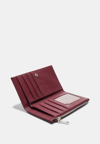 Bordová kožená peňaženka s viacerými priehradkami na karty, priehľadným okienkom na preukaz a vreckom so zipsom. Hladká textura, minimalistický dizajn.