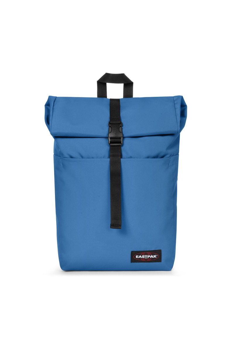 Blå rulltoppryggsäck gjord av slitstarkt tyg, med en framknäppning, handtag upptill och Eastpak-logotyp längst ner.