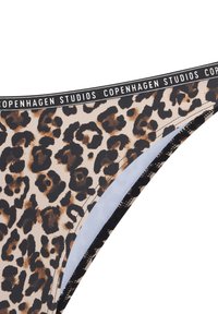 Bikini spodnji del z leopardjim vzorcem in črnim elastikastim pasom, ki vsebuje besedilo "Copenhagen Studios", mehkega materiala in ukrivljenega dizajna.