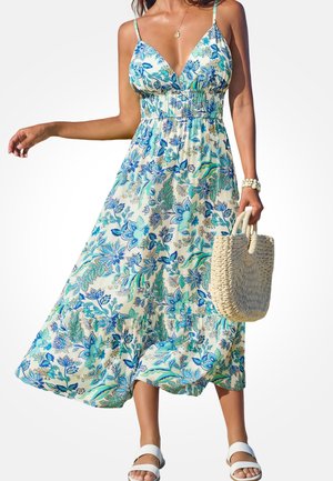 Maxi-jurk met bloemenprint in crème, met blauw- en groene patronen, verstelbare bandjes en een geplooide bovenkant. Gecombineerd met een geweven handtas.