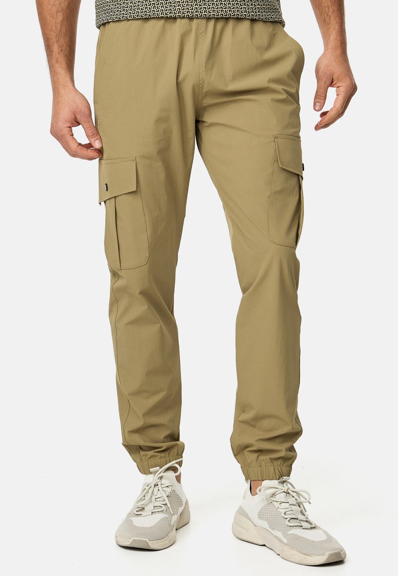 Khaki cargo bukser med elastisk talje, sidelommer og elastiske manchetter. Lavet af letvægtsstof med en glat tekstur.