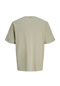 Μπεζ βαμβακερό κοντομάνικο μπλουζάκι, εμφανιζόμενο από πίσω, με στρογγυλή λαιμόκοψη και μια μικρή ραμμένη ετικέτα με το λογότυπο κοντά στο γιακά.