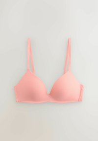 Soutien-gorge rose doux légèrement rembourré avec fines bretelles réglables et bonnets moulés lisses, posé à plat sur un fond neutre.
