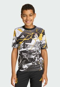 Sort-hvid grafisk T-shirt med gule accenter, der viser tegneseriestil-karakterer og lynmotiver. Rund hals og korte ærmer.