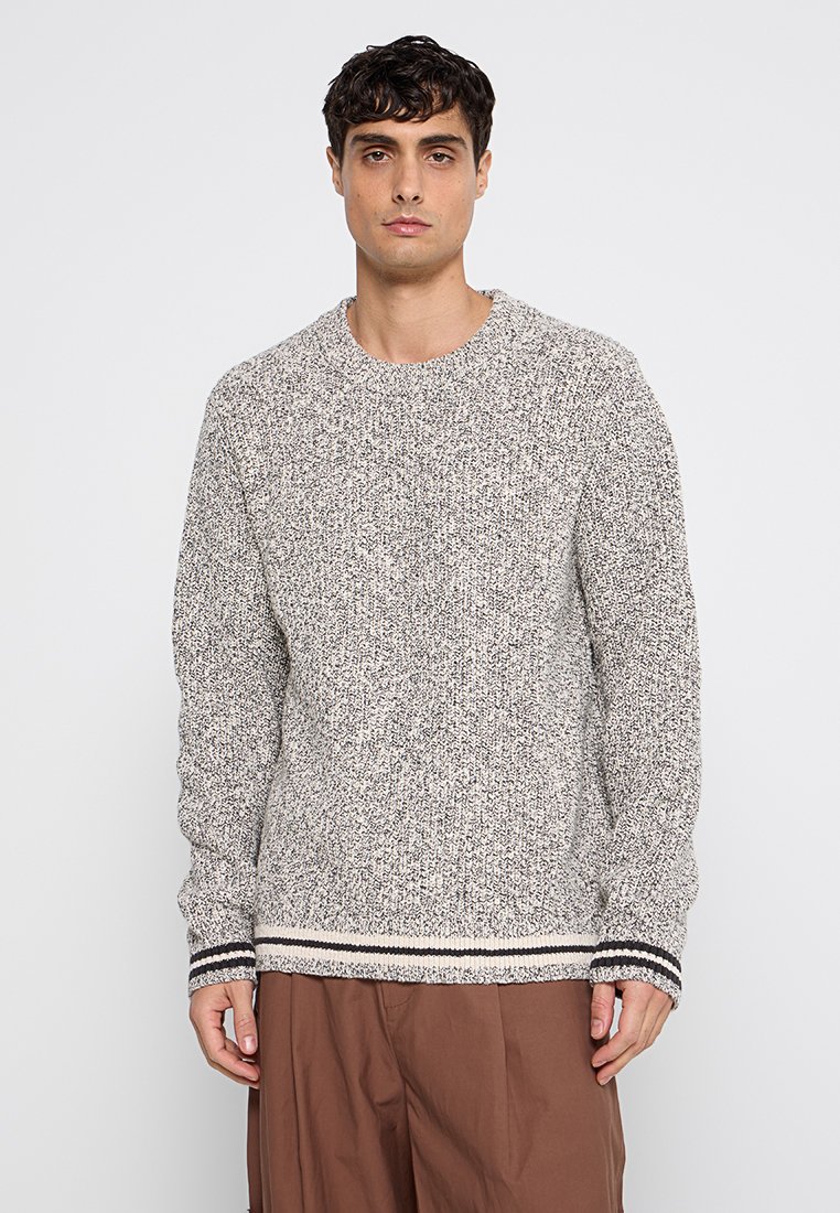 Helles graues Strickoberteil mit strukturierter Oberfläche. Verfügt über einen runden Ausschnitt und gestreifte Rippbündchen sowie einen Saum in Dunkelgrau und Creme.