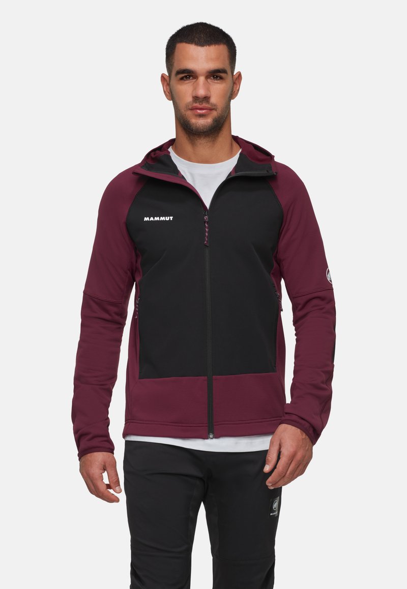 Veste bordeaux et noire en tissu respirant, dotée d'une fermeture éclair sur le devant, de poches latérales et d'un logo sur la poitrine et la manche.