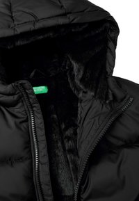 Černá puffová bunda s kapucí, s měkkou podšívkou z černého umělého kožešiny. Má zipové zavírání a zelenou značkovou etiketu uvnitř.