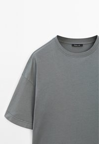 Grå bomulds t-shirt med rund halsudskæring og korte ærmer. Har pæn syning og et mærke med brandnavnet på den indre krave.