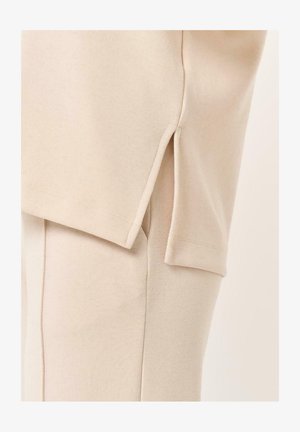 Beige katoenen blend top met zijsplitten en korte mouwen, met een ontspannen pasvorm en een gladde textuur.