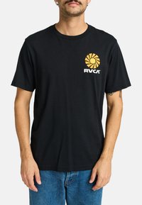 Sort bomulds T-shirt med korte ærmer og rund halsudskæring, med en gul solgrafik og hvid "RVCA" logo på brystet.