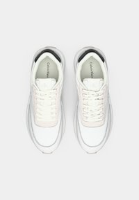 Biele a svetloružové sneakers so hladkým koženým zvrškom, okrúhlou špičkou, šnurovacím zapínaním a čiernym akcentom na päte.