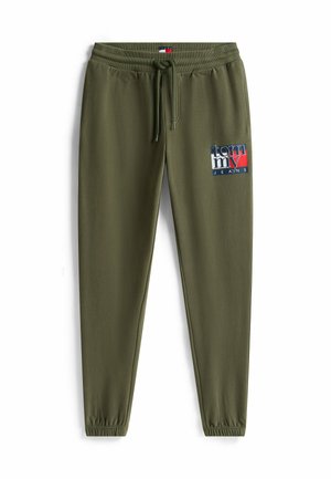 Olivgrüne Jogginghosen mit elastischem Bund, Kordelzug und schmal zulaufenden Beinen. Auf dem Oberschenkel befindet sich ein Logoschild in Rot, Weiß und Blau.