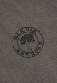 Ciemnoszary materiał dziany z czarnym, okrągłym logo przedstawiającym drzewo oraz napisem "BLK VIS EST. 2016" umieszczonym na środku.