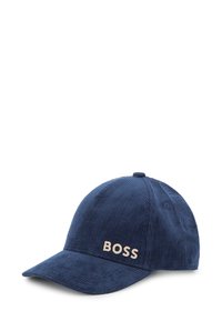 Casquette de baseball en velours côtelé bleu marine avec un design structuré, présentant un logo "BOSS" beige à l'avant. Visière courbée et détails de couture.