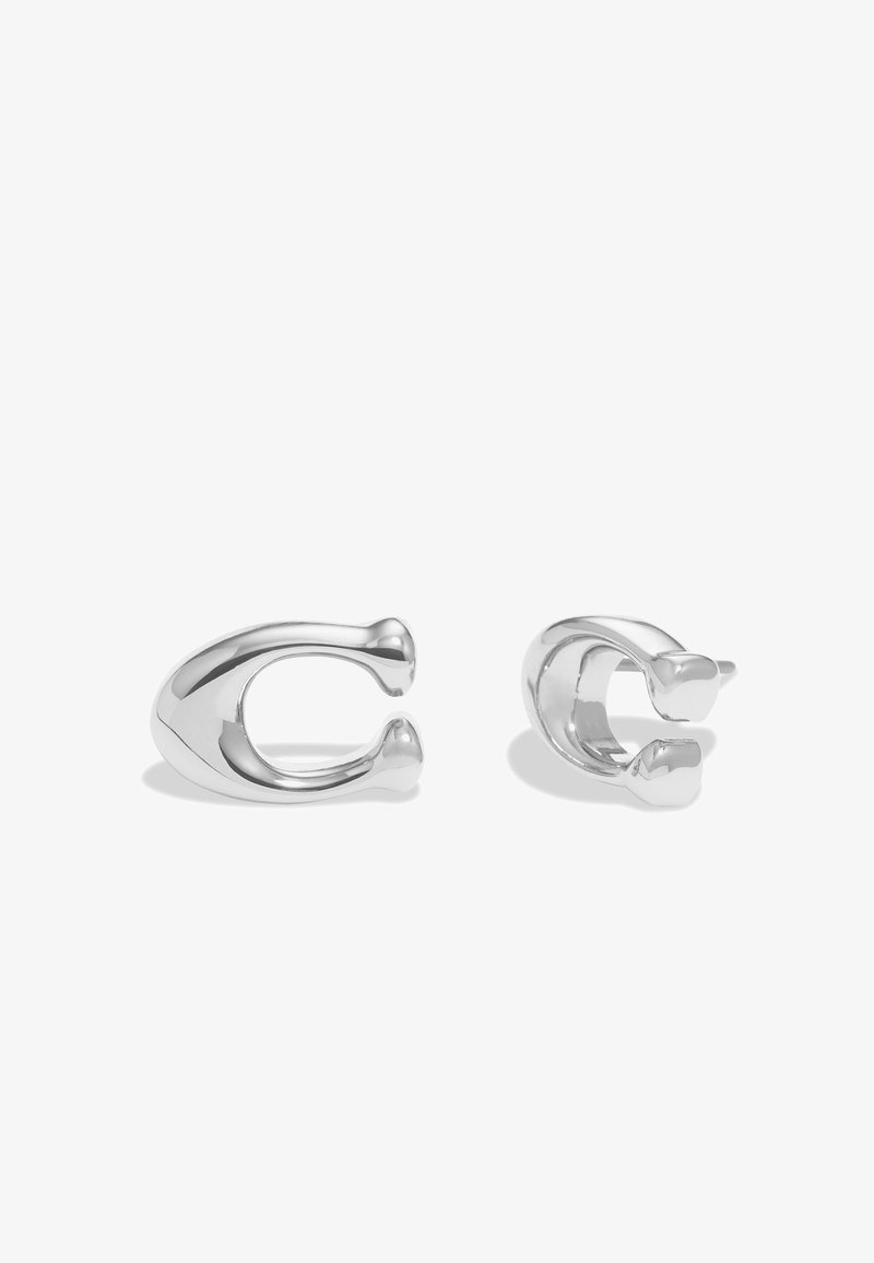 Pendientes de metal plateado en forma de "C" alargadas y curvadas con superficies lisas y extremos redondeados, que presentan un acabado pulido.