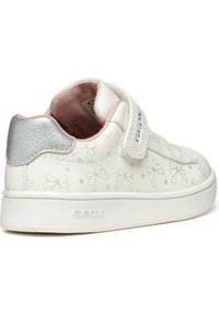 Sneaker bianca con un sottile fiocco e motivo a pois, accentuazione argentata sul tallone, fascia in velcro e suola in gomma testurizzata. Marchio Geox stampato di lato.