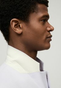 Light purple shirt with a structured, white collar. Smooth fabric with a tailored fit, showcasing a sleek design and clean lines.