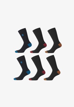 Six chaussettes noires avec des accents colorés sur les orteils : bleu, rouge et orange, présentant des motifs géométriques sur les semelles et un logo sur les poignets.