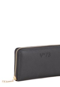 Portafoglio in pelle nera con finitura testurizzata, hardware della cerniera dorato e logo impresso. Design sottile, forma rettangolare e dettagli minimi.