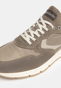 Baskets pour hommes en suède taupe et mesh, avec des lacets ronds, une semelle blanche et une étiquette de logo près du haut. Textures lisses et accents.