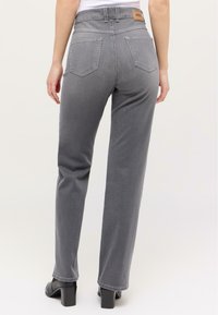 Graue Denim-Jeans mit hoher Taille, geraden Beinen und zwei Gesäßtaschen. Mit einem Leder-Label am Bund und einer glatten Textur.