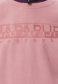 Felpa rosa chiaro con un nome di marca testurizzato e in rilievo sul petto. Presenta un collo a girocollo a costine e un morbido tessuto di cotone.