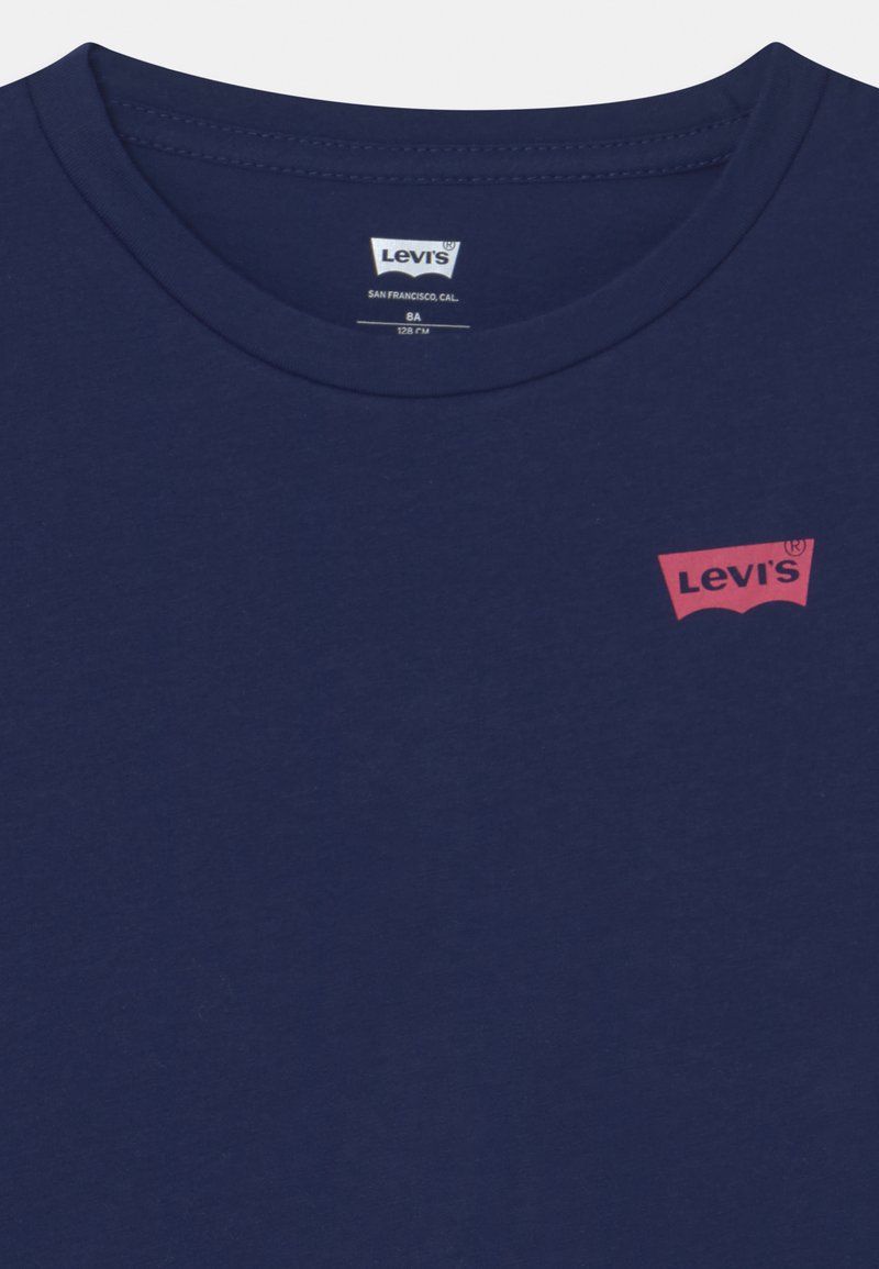 T-shirt in cotone blu navy caratterizzata da un colletto a girocollo e da una grafica del logo rosso Levi's sulla parte superiore sinistra. Texture liscia e design essenziale.
