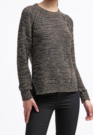 Sweter dzianinowy w plamkowanym czarno-beżowym wzorze. Posiada okrągły dekolt i ściągacze, z luźnym, lekko swobodnym krojem.