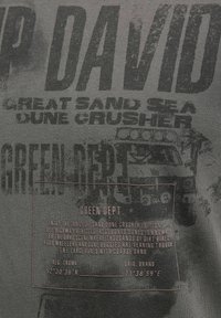Text on gray fabric with phrases "DAVID," "Great Sand Sea Dune Crusher," "Green Dept," and coordinates alongside a graphic of an off-road vehicle.