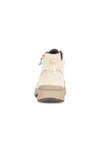 Beige hoge topschoenen met een glad leren bovenwerk, een contrasterende donkerdere zool en een rits aan de achterkant voor gemakkelijk aan- en uittrekken.