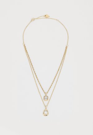 Collana a strati in oro con due catene. Una catena presenta un pendente rettangolare, mentre l'altra ha un pendente a forma di goccia con una pietra trasparente.