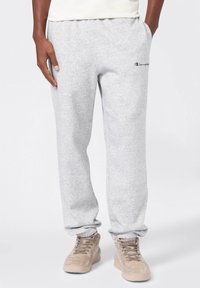 Pantaloni sportivi grigi realizzati in cotone misto, con una vestibilità ampia, cintura elastica, tasche laterali e un piccolo logo blu navy sulla coscia sinistra.