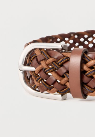 Ceinture tressée en cuir brun et tissu avec boucle en métal argenté et passant en cuir sur un fond clair.