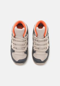 Sneakers with a gray and cream mesh upper, textured rubber sole, orange padded collar, and contrasting black accents. Five eyelets and laces.