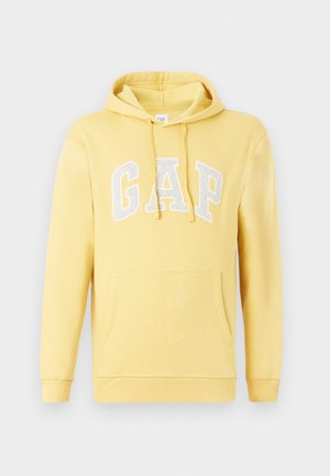 Kollane kapuutsiga sviiter, mis on valmistatud pehmest materjalist. Omab esi-taskut, reguleeritavat kapuutsi ning halli "GAP" logo rinna peal.