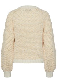 Pull en maille épaisse crème et pêche avec poignets et ourlet côtelés, présentant un motif texturé et des manches longues.