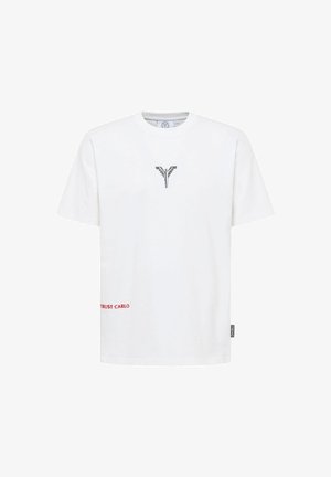T-shirt en coton blanc avec un design graphique gris au centre, et un texte rouge disant "TRUST CARLO" près du coin inférieur gauche.