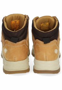 Botas de senderismo de cuero marrón con un collar de malla, refuerzo en el talón y suelas de goma. Presentan un logo y una pestaña de agarre para ponerlas fácilmente.