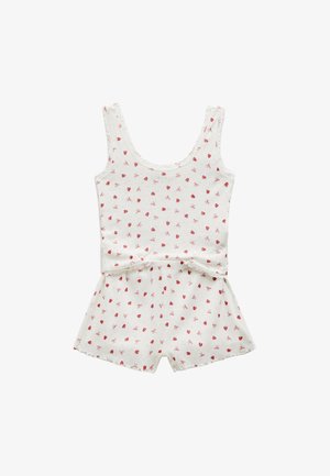 Combinaison en coton blanc avec un motif de cerises rouges et de nœuds dispersés, dotée d'un décolleté plongeant et de shorts. Texture douce et coupe décontractée.