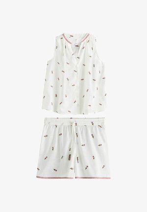 Fehér ujjatlan felső és rövidnadrág szett, apró rózsaszín virágmintával, rózsaszín szegéllyel a nyakkivágáson és a rövidnadrág alján, valamint húzózsinóros derékpánttal a rövidnadrágon.