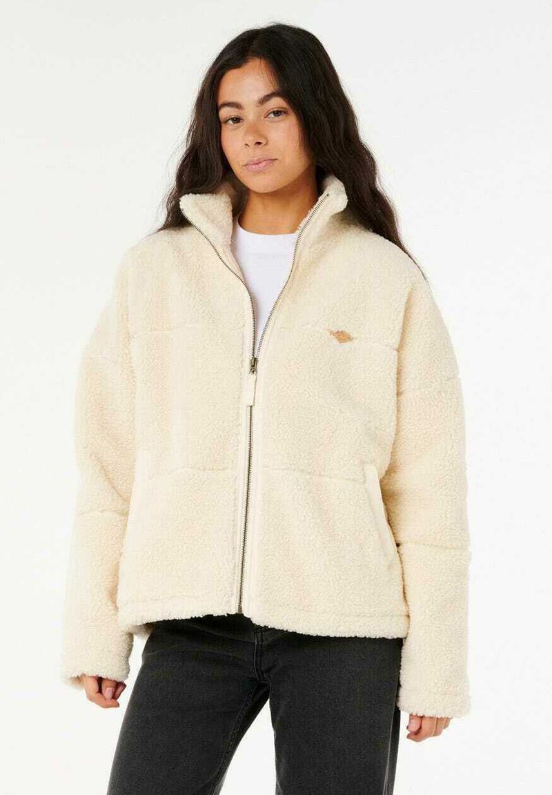 Crème-kleurige fleece jas met een rits aan de voorkant, hoge kraag en twee voorzakken. Zachte textuur en een klein logo op de linkerborst.