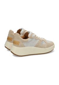 Zapatillas de ante beige y cuero suave con una suela de plataforma blanca texturizada, que cuentan con un panel lateral perforado y acentos en contraste.