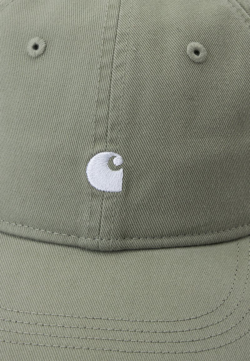 Olivgrüne Baseballkappe mit gebogenem Schirm und einem kleinen weißen, gestickten runden Logo auf dem vorderen Mittelpanel.