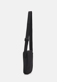 Black fabric crossbody bag with a slim rectangular shape, adjustable strap, and smooth texture. Features no visible hardware or patterns.