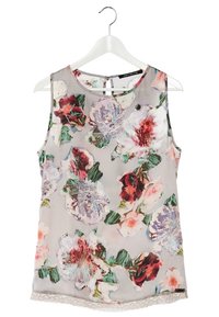 Blouse sans manches à imprimé floral multicolore avec de grandes fleurs sur tissu gris clair, suspendue à un cintre blanc.